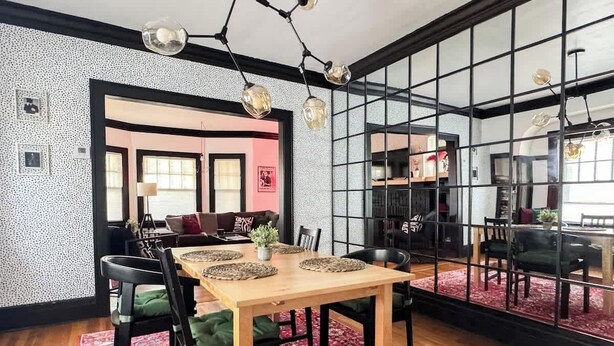 A dining area with a wooden table, chairs, and a red patterned rug. - Rock and Roll House of Fame! 2bed 1bath Central AC (Lakewood)