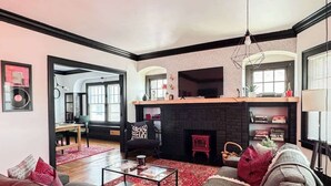 A living room with a fireplace, a sofa, a coffee table, and a bookshelf. - Rock and Roll House of Fame! 2bed 1bath Central AC (Lakewood)