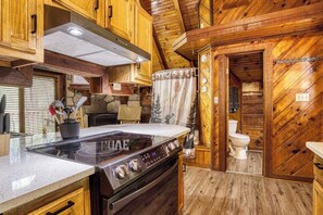 Una cocina con armarios de madera, una estufa y un fregadero.