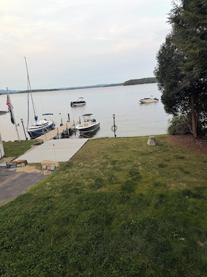 A grassy area with a dock and boats.
