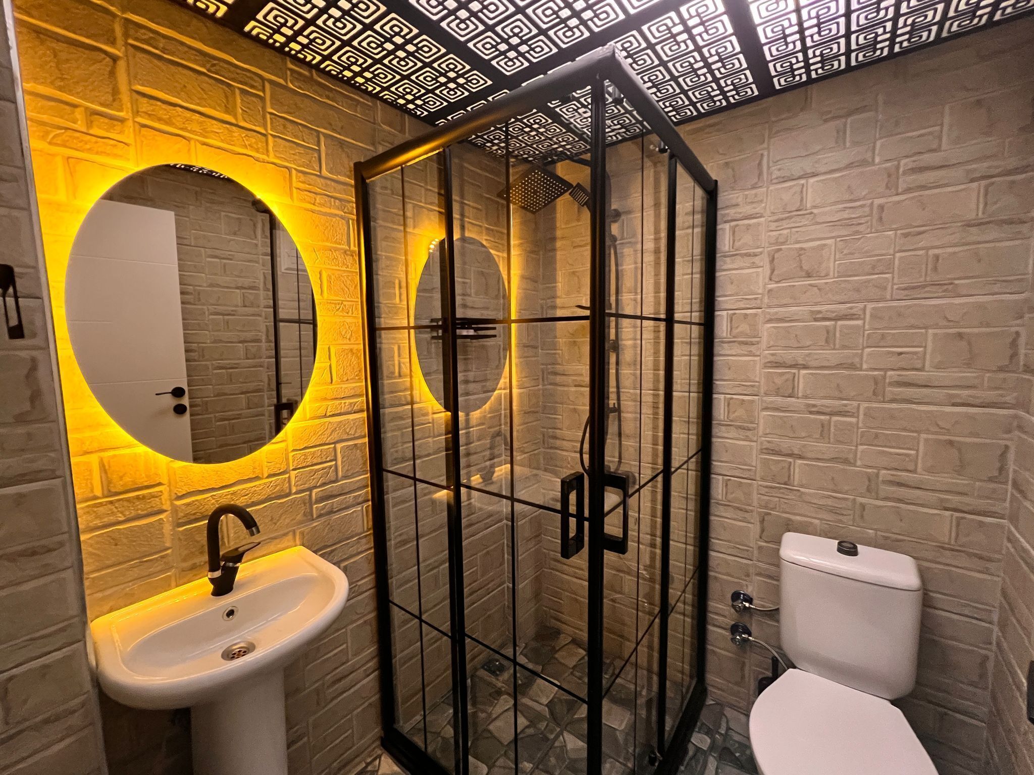 Een badkamer met een wit wastafel, toilet en een douchecabine.