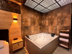 A modern bathroom with a freestanding bathtub, wooden wall paneling, and a ceiling light fixture.
