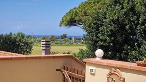 A balcony with a view of the sea, a wooden gate, and a traditional water fountain. - Podere Isabella - Mandarin apartment with large terrace overlooking the sea (Toscana)