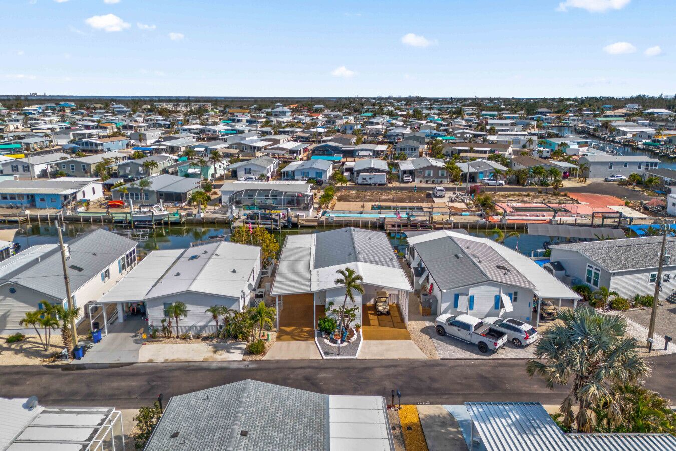 A residential area with houses, a marina, and a clear sky.