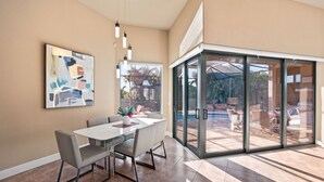A modern dining area with a glass door leading to an outdoor patio.