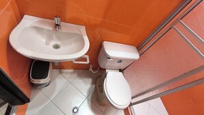 A bathroom with a white sink, a toilet, and a bidet. - Apartment in Colombian Santorini (Doradal)