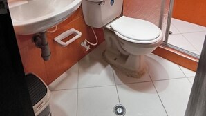 A bathroom with a white sink, toilet, and shower. - Apartment in Colombian Santorini (Doradal)