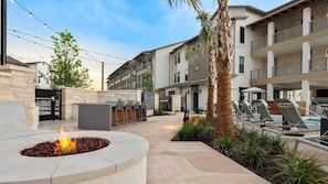 A courtyard with a fire pit, outdoor seating, and a pool area. - Landing | Spectacular 1BD, Clubhouse, Pool (Lakeway)