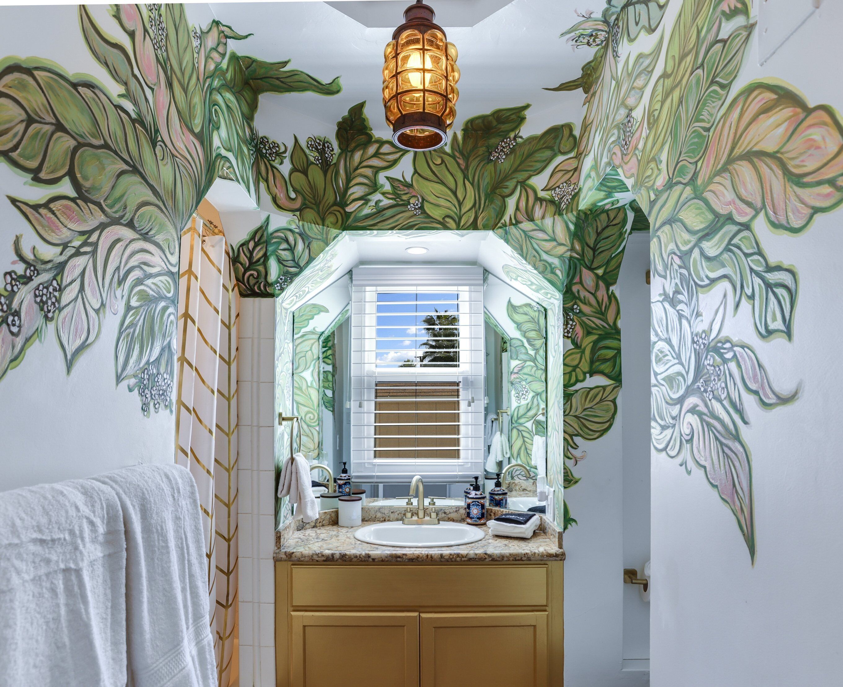 A bathroom with a large window, a sink, and a towel hanging on the wall.