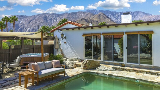 Un espace piscine doté d’un jacuzzi, de coins salon extérieurs et offrant une vue sur les montagnes.