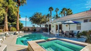 A swimming pool with a tiled deck, lounge chairs, and a patio area with tables and chairs. - Flora Vista Sunshine (Palm Springs)