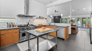 Una cocina moderna con electrodomésticos de acero inoxidable, una isla central y vistas al exterior.