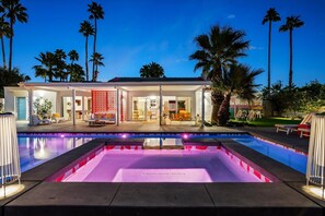 A modern house with a swimming pool, palm trees, and a well-lit patio area. - Birdcage Palm Springs (Palm Springs)