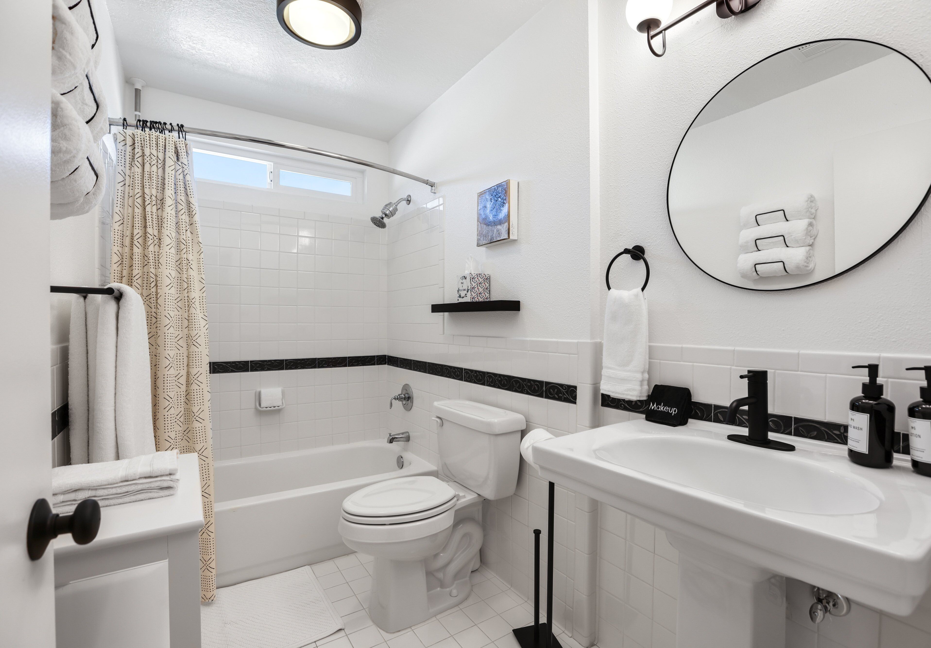 A modern bathroom with a bathtub, toilet, and sink.