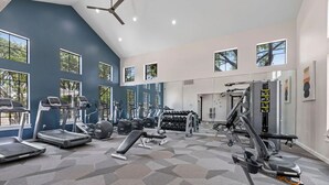 A gym with treadmills, elliptical machines, and weightlifting equipment. - Landing | Beautiful 2BD, Gym (Houston)