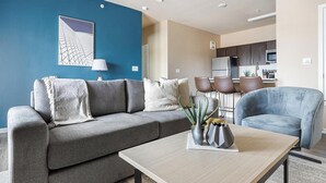 Een moderne woonkamer met een grijze bank, een salontafel en een blauwe accentmuur.