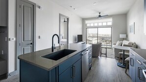 Una cocina moderna con una isla grande, electrodomésticos integrados y vistas a la ciudad.