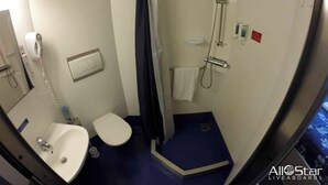 A compact bathroom with a shower, toilet, and sink.