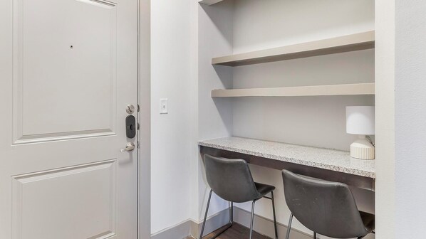 A small, private office with a desk, two chairs, and a white door.