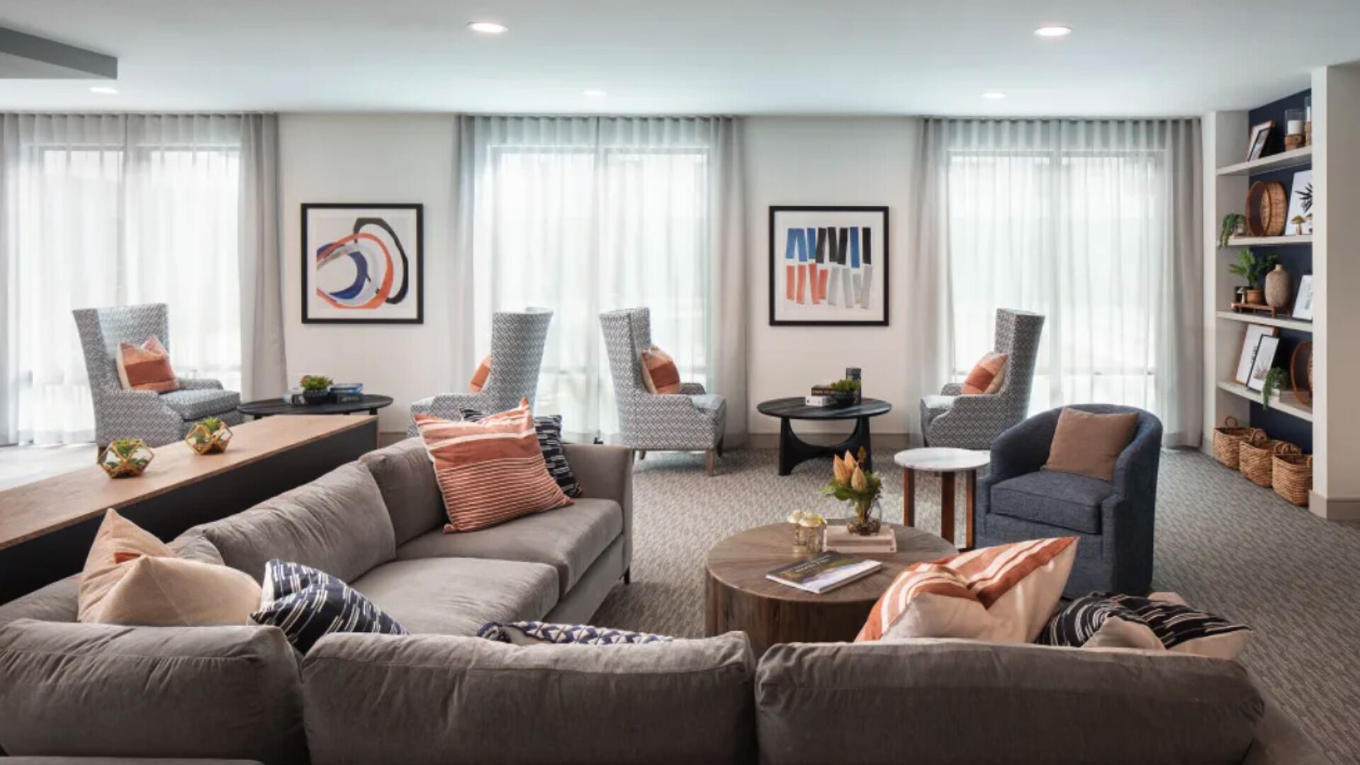 A modern living room with a sofa, armchairs, a coffee table, and artwork on the walls.