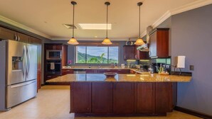 A modern kitchen with a large island, stainless steel appliances, and pendant lighting. - Malinche 422B- Ocean view condo at Reserva Conchal (Reserva Conchal)