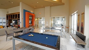 A spacious living area with a pool table, a billiards rack, and a billiards table.