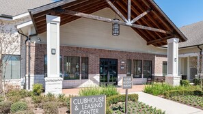 A clubhouse and leasing center with a brick facade, large windows, and a covered entrance. - Landing | Stunning 1BD, Clubhouse, Courtyard (Katy)