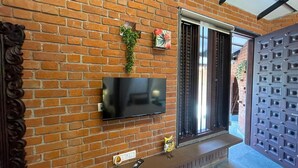 Un muro de ladrillo con un televisor de pantalla plana montado sobre un banco de madera.