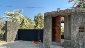 Un edificio de piedra con puerta de madera y un portón negro.