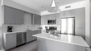 Una cucina moderna con elettrodomestici in acciaio inox, un'isola centrale e un design elegante.
