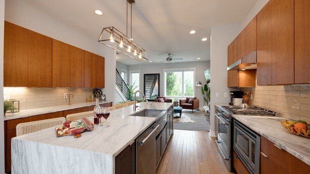 A modern kitchen with a large island, wooden cabinets, and stainless steel appliances. - Vivid Vocals - 4 Mins to Broadway - Rooftop Patio (Nashville)