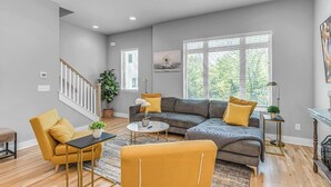 A modern living room with a gray sofa, yellow armchairs, and a coffee table. - Nashville Nest - Rooftop Patio - Mins To Broadway (Nashville)