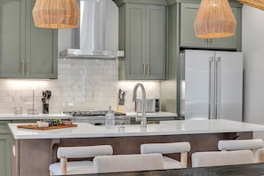 A modern kitchen with a central island, stainless steel appliances, and green cabinets. - Alto-private Rooftop Deck-8 Mins to Broadway (Nashville)