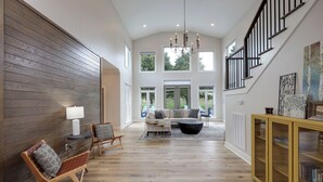 A spacious living area with a high ceiling, a staircase, and large windows. - Majestic Manor-private Hundred Acre Yard-pool/spa (Lebanon)