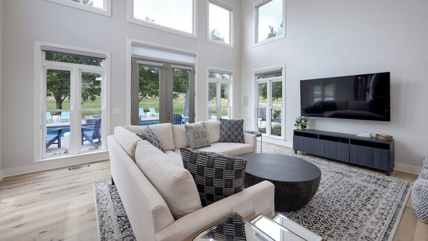 A spacious living room with a large sectional sofa, a flat-screen TV, and a view of a backyard patio. - Majestic Manor-private Hundred Acre Yard-pool/spa (Lebanon)