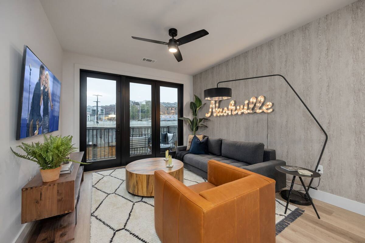 A modern living room with a sofa, coffee table, and a ceiling fan.