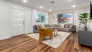 Una sala de estar moderna con un sofá seccional, una mesita de centro y un diseño minimalista.