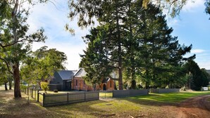 A rural property with a large tree, a brick building, and a fenced area. - Glenlyon Church - Award Winning Church Conversion (Glenlyon)