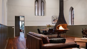 A modern interior with a leather sofa, a dining table with chairs, and a large fireplace. - Glenlyon Church - Award Winning Church Conversion (Glenlyon)