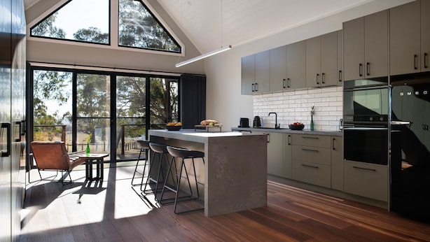 A modern kitchen with a large island, bar stools, and a view of the outdoors. - Glenlyon Church - Award Winning Church Conversion (Glenlyon)
