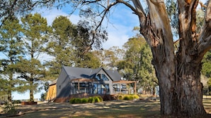 A modern house with a large glass window, surrounded by trees and a grassy yard. - Glenlyon Church - Award Winning Church Conversion (Glenlyon)