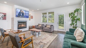 A modern living room with a fireplace, comfortable seating, and large windows. - Verde Heights-sleeps 12-in Cumberland Heights (Nashville)
