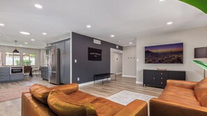 A modern living room with leather sofas, a kitchen area, and a dining space. - Desert Rose-hot Tub-pool Heat Avail-fire Pit-golf! (Scottsdale)