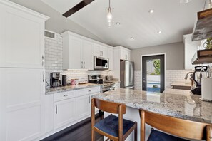 A modern kitchen with white cabinets, stainless steel appliances, and a granite countertop. - La Privada Stay-heated Pool-in North Scottsdale (Scottsdale)
