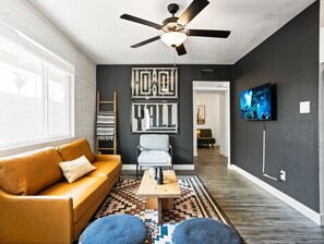 A modern living room with a sofa, armchair, coffee table, and a ceiling fan. - Colt-in Old Town-walk To Entertainment District (Scottsdale)
