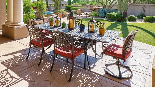 An outdoor patio with a table and chairs, surrounded by cacti and palm trees. - Valley View Villa - Private Pool - Hidden Bedroom (Scottsdale)
