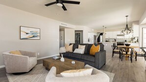 A modern living room with a sofa, armchairs, and a coffee table. A dining area with a table and chairs is visible in the background. - Sereno - Sparkling Pool - Near Scottsdale Quarter (Scottsdale)