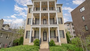 A multi-story building with a central entrance, balconies, and a sign reading "3100 BELWOOD STREET".