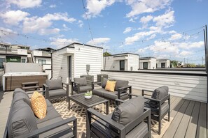 An outdoor patio area with a barbecue, seating, and string lights. - Revival-rooftop Deck/hot Tub- Mins to Broadway (Nashville)
