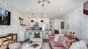 A modern living room with a sofa, coffee table, and TV. - Revival-rooftop Deck/hot Tub- Mins to Broadway (Nashville)